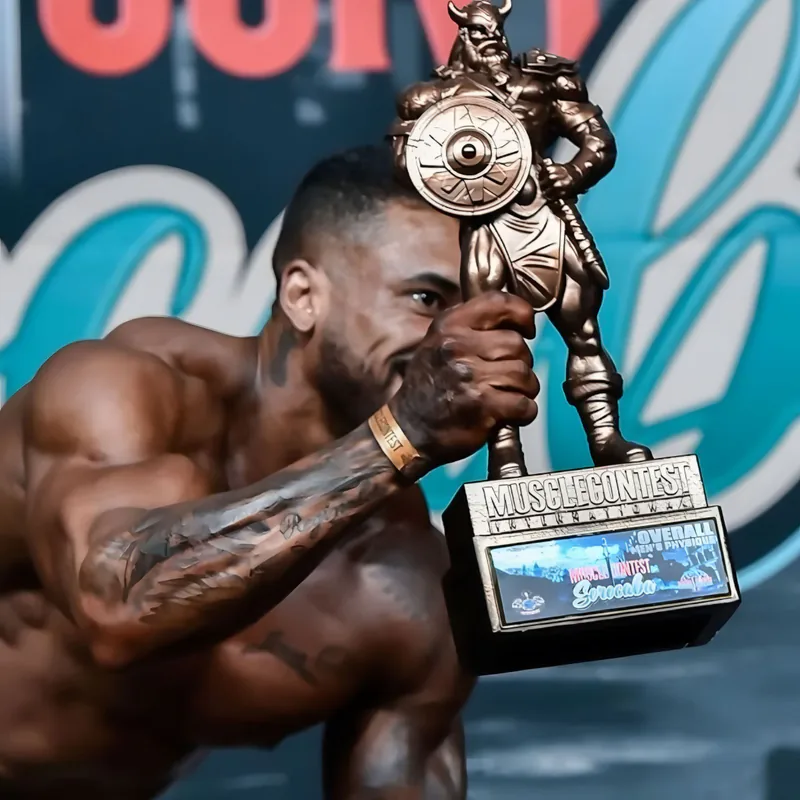 Canidia Santos segurando troféu de campeão no palco